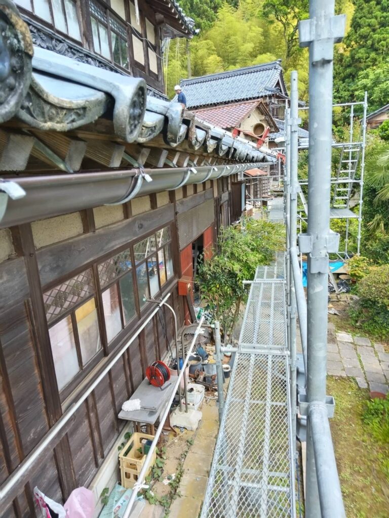建物の外周に足場を設置しました。木枠のガラス窓が見えています。外窓交換をします。