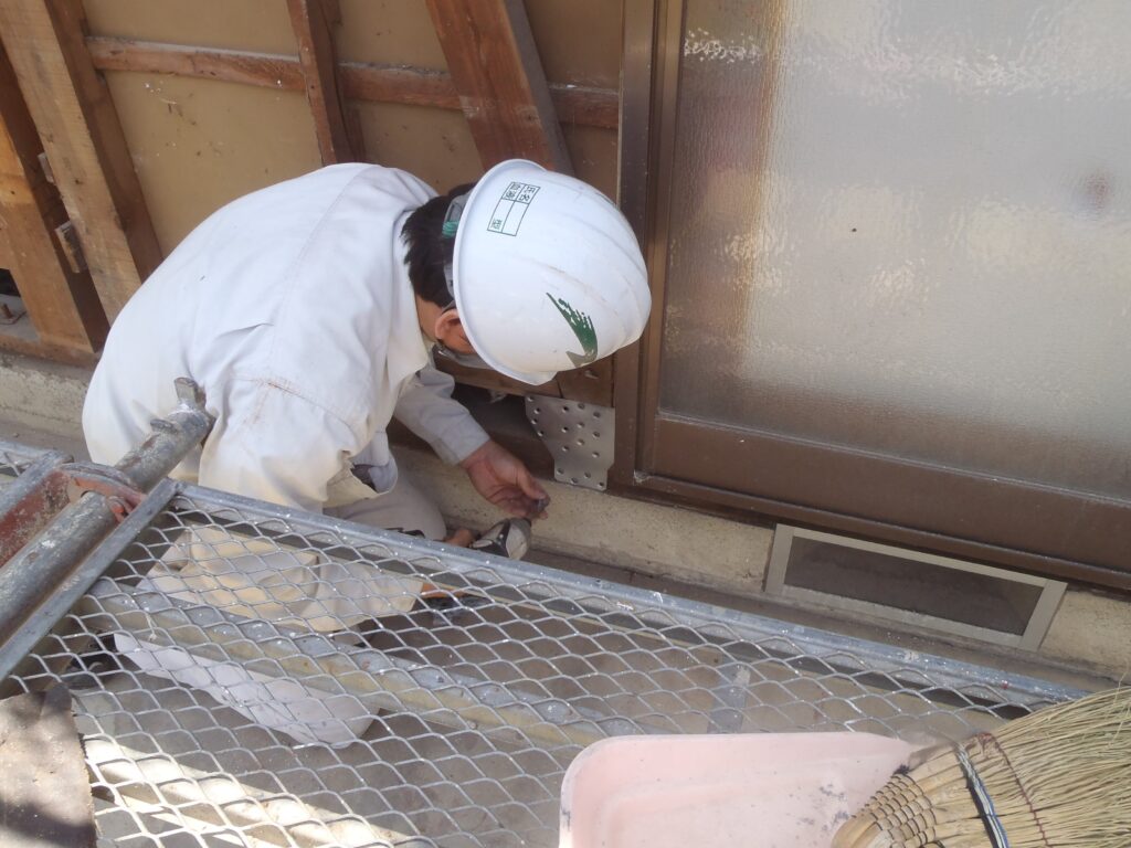 柱と基礎、柱と梁に金物を取り付けて補強します。