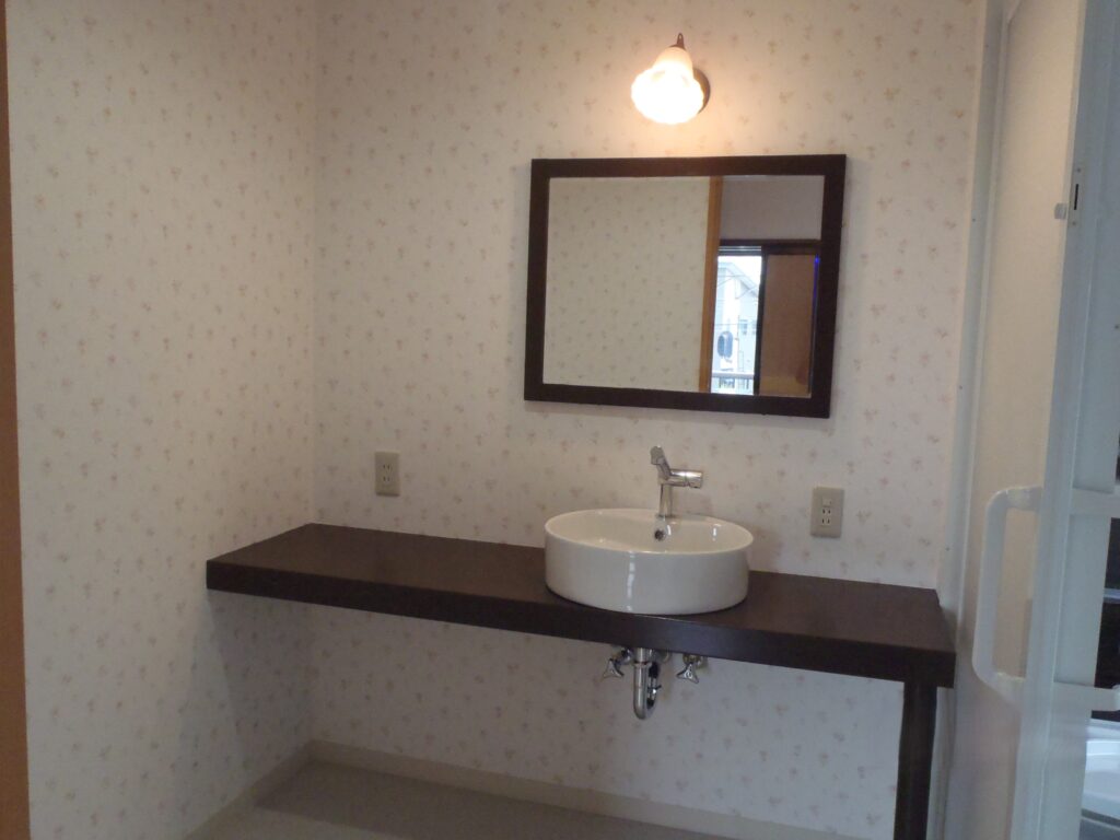 カウンターの一枚板に塗装を施し、洗面台の下台に。グッと空間が引き締まりました。洗面ボウル、蛇口はイタリア製スカラベオ社の製品です。ボウルはそこが深い設計なので小さな衣類なら洗濯可能ですね。奥様お気に入りの空間です。