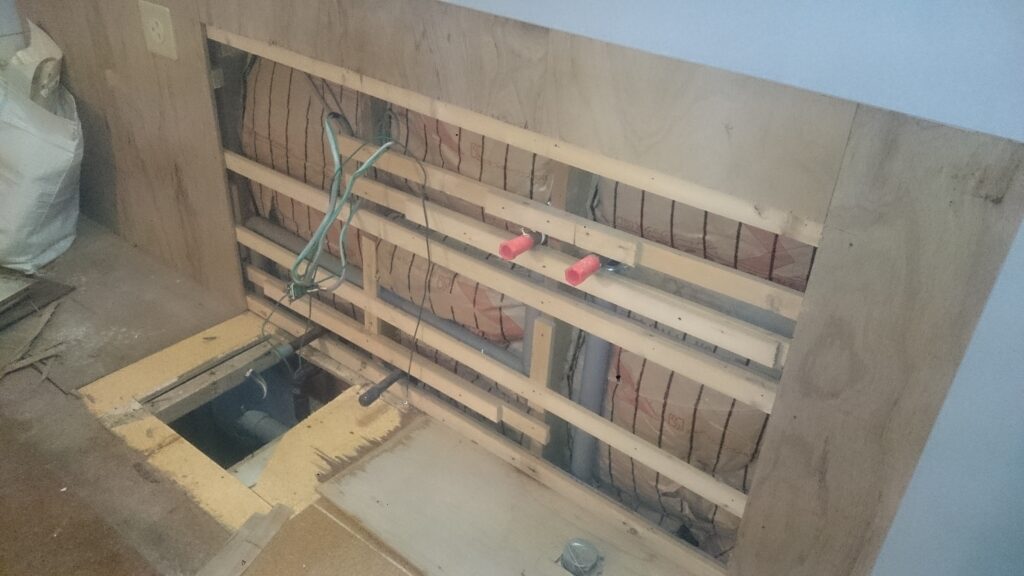 給排水位置を変更するために壁と床をめくって施工しています。