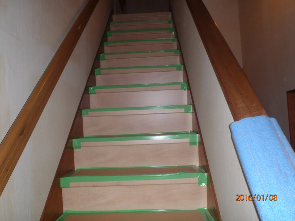 階段踏み板は質感のある表面仕上げで汚れや傷に強い製品です。既存の蹴込み板を重ね貼りします。養生して傷が付かない様にしています。