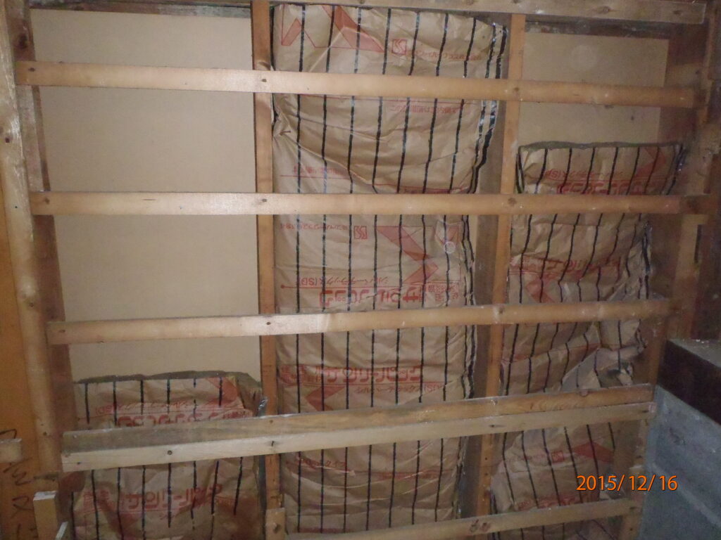 洗面脱衣室の壁になります。壁を剥がすと下地材、断熱材が見えてきました。古い断熱材が入っていますが落下しているのがわかります。これでは、断熱性能が十分に発揮されません。そこで、古い断熱材を撤去して新たに高性能な断熱材を充填していきます。