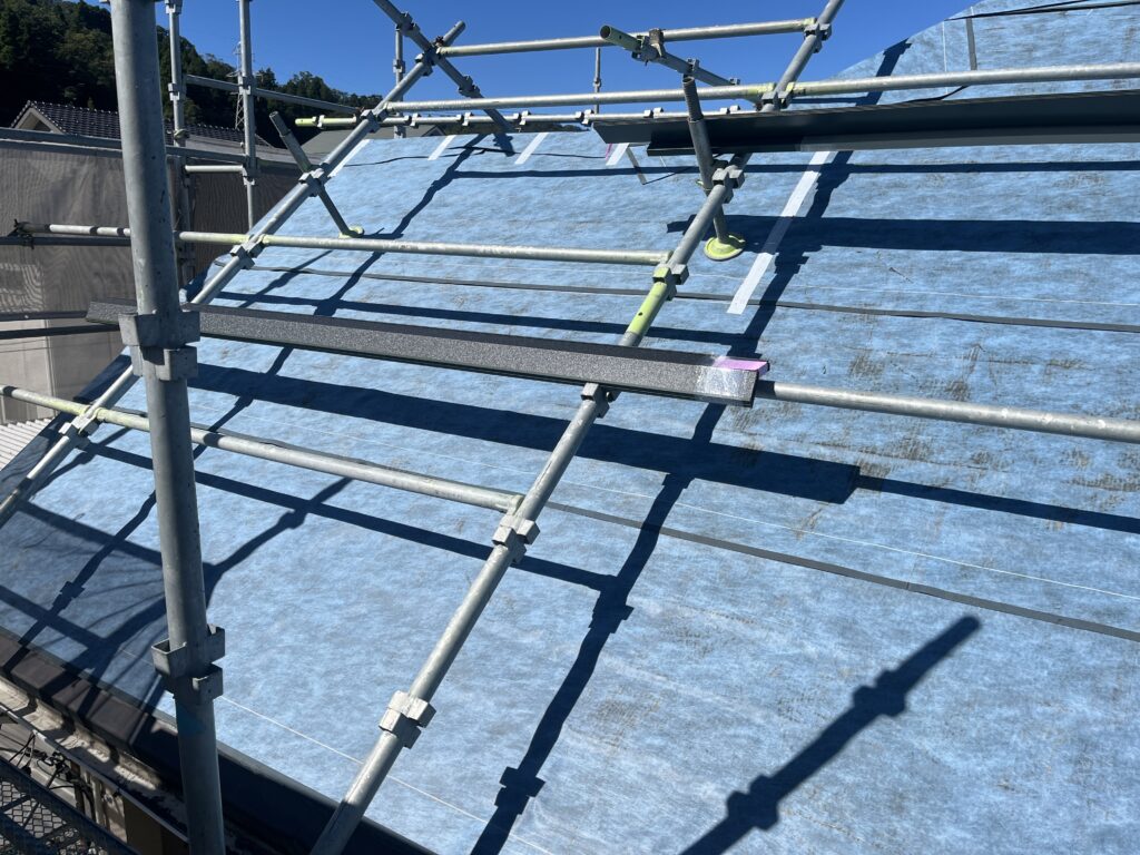 その後、防水シート（アスファルトルーフィング）を敷設し、雨水の浸入を防ぐ下地をしっかりと整えています。