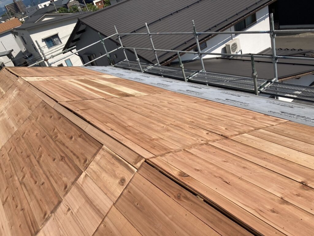 傷んでいた下地を直し、瓦の土台となる新しい木板（野地板）を隙間なく敷き詰めていきます。屋根全体の強度を高める重要な工程です。